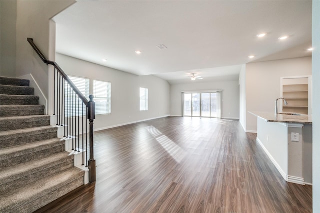 unfurnished living room with sink, dark wood-type flooring, and ceiling fan