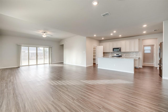 unfurnished living room featuring ceiling fan and light hardwood / wood-style flooring