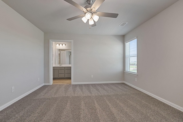 unfurnished bedroom with light carpet, sink, ensuite bath, and ceiling fan