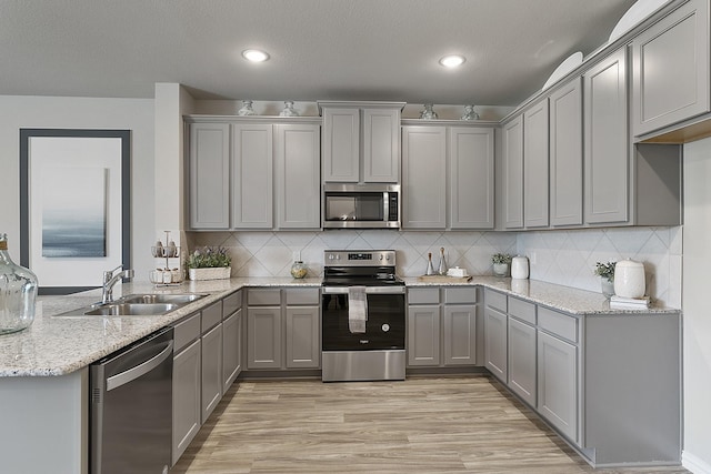 kitchen with stainless steel appliances, gray cabinets, and sink