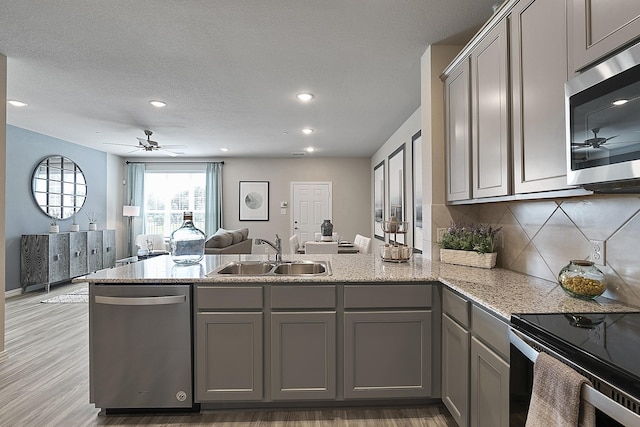 kitchen with decorative backsplash, appliances with stainless steel finishes, gray cabinetry, and sink