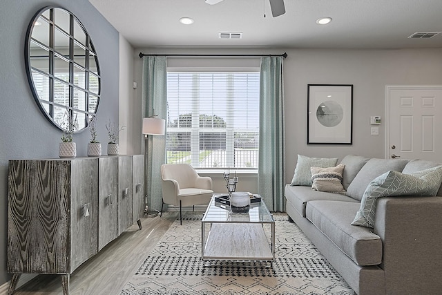 living room featuring light hardwood / wood-style flooring and ceiling fan