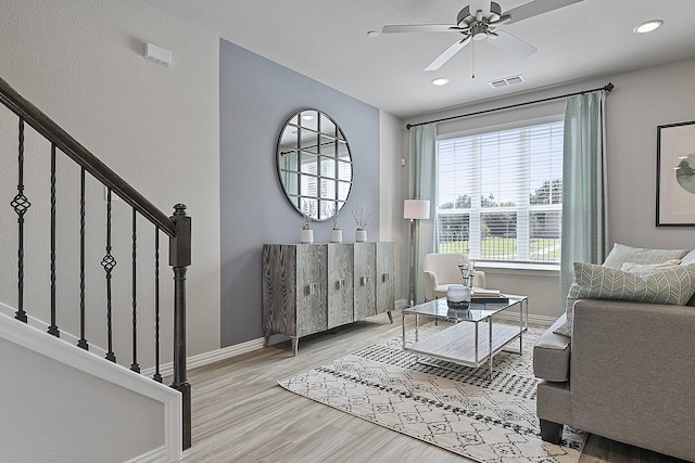 living room featuring light hardwood / wood-style floors and ceiling fan