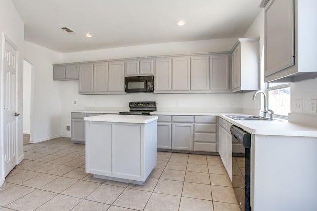 kitchen with a center island, black appliances, sink, gray cabinets, and light tile patterned floors