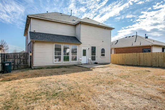 rear view of property with a lawn and a patio