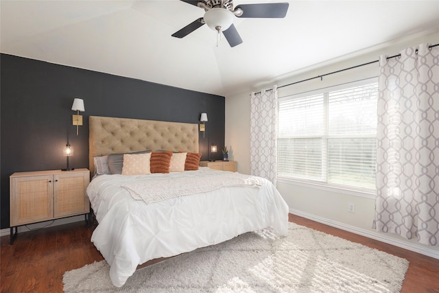 bedroom featuring multiple windows, dark hardwood / wood-style floors, and ceiling fan