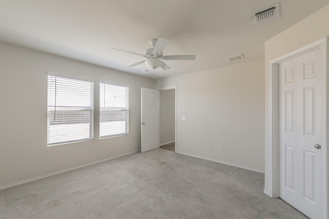 empty room with ceiling fan and light colored carpet