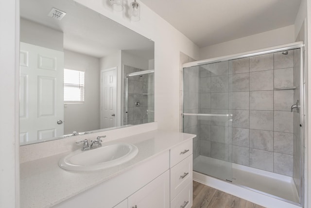 bathroom with vanity, wood-type flooring, and walk in shower