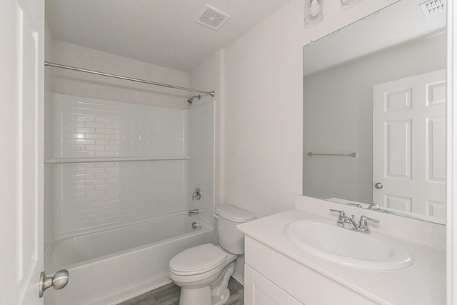 full bathroom featuring tiled shower / bath, vanity, and toilet