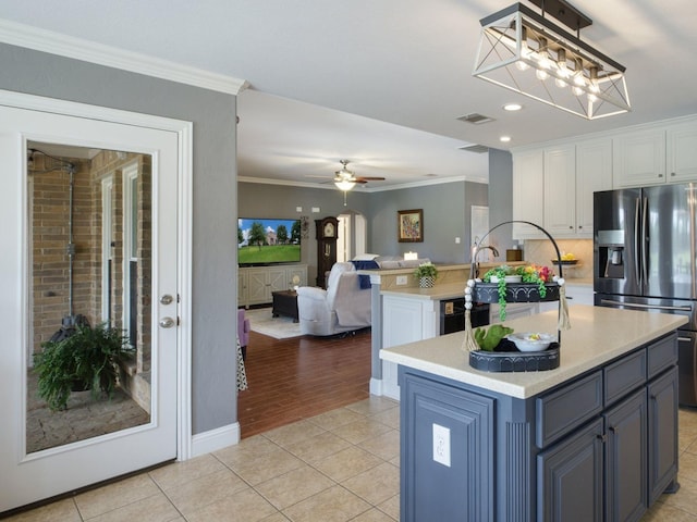 kitchen with a center island, crown molding, ceiling fan, white cabinetry, and stainless steel fridge with ice dispenser