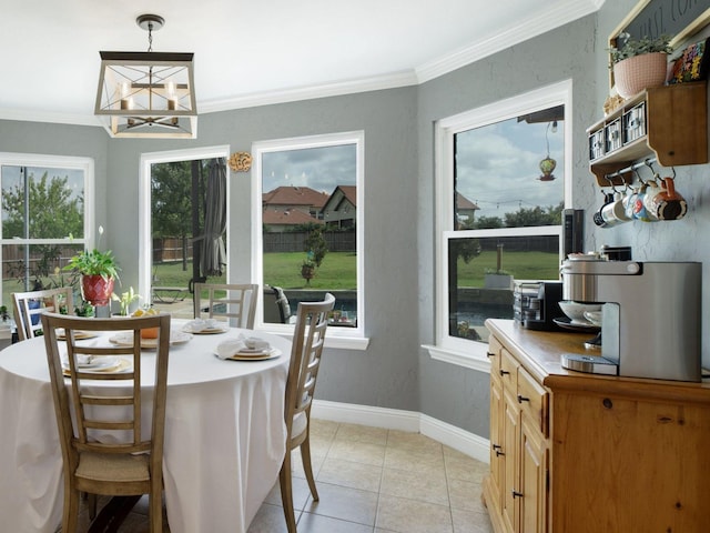 tiled dining space featuring a notable chandelier and ornamental molding