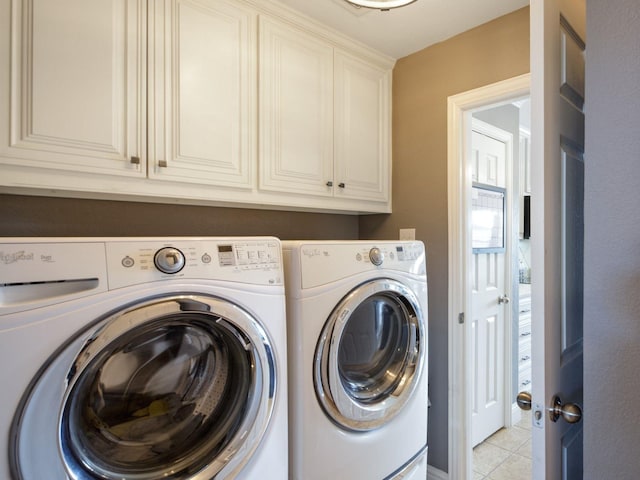 laundry room with separate washer and dryer, light tile patterned flooring, and cabinets