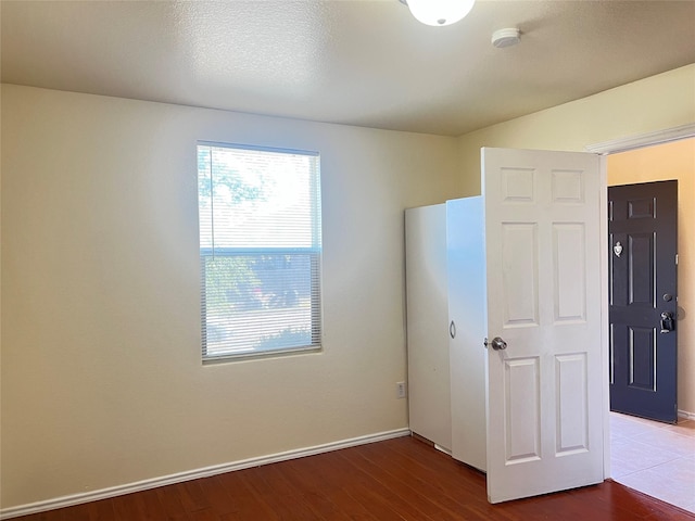 unfurnished bedroom featuring hardwood / wood-style floors and a textured ceiling