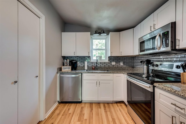 kitchen featuring sink, white cabinetry, appliances with stainless steel finishes, and stone counters