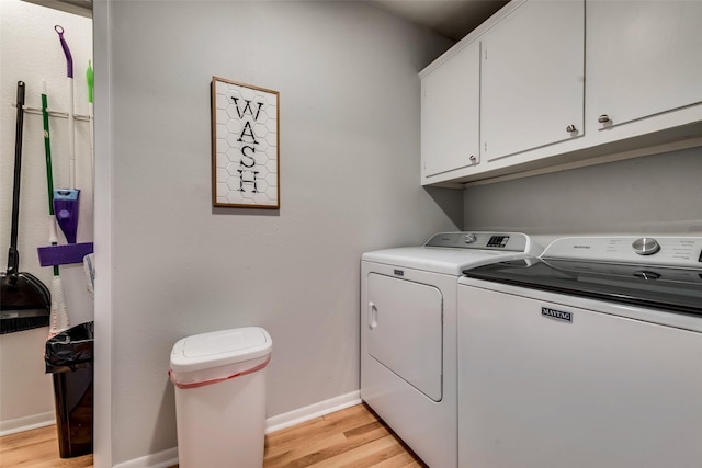 washroom with light hardwood / wood-style flooring, cabinets, and washer and dryer