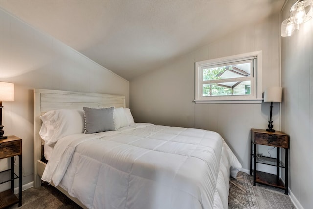 bedroom with dark carpet and vaulted ceiling