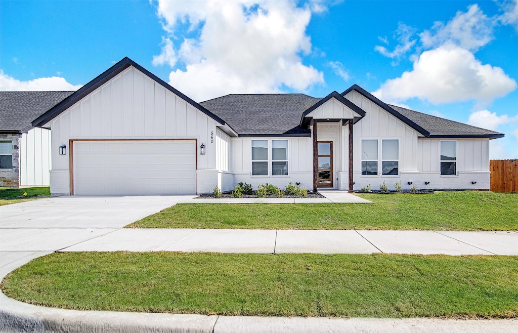 modern farmhouse style home with a garage and a front lawn