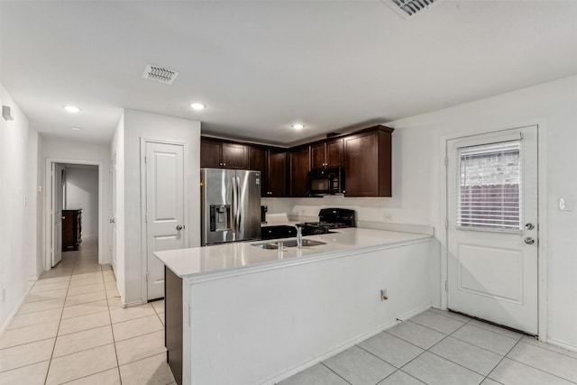 kitchen featuring black appliances, kitchen peninsula, sink, and light tile patterned floors