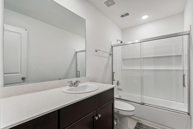 full bathroom featuring tile patterned floors, toilet, vanity, and combined bath / shower with glass door