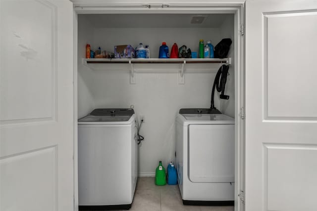 washroom featuring light tile patterned flooring and washing machine and dryer