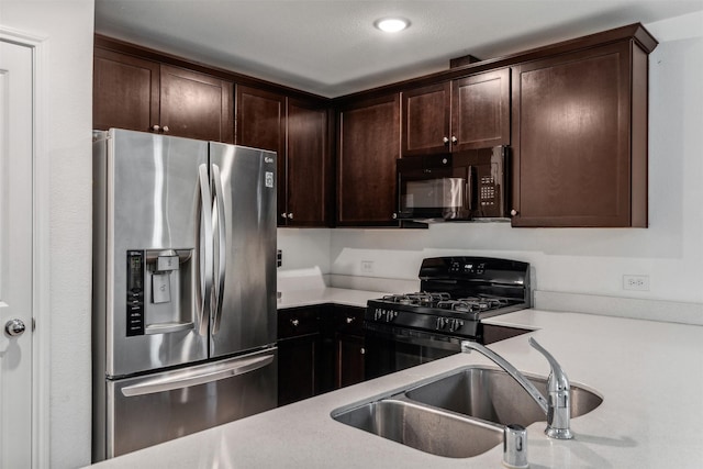 kitchen with dark brown cabinetry, sink, and black appliances