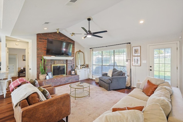 living room with hardwood / wood-style floors, ceiling fan, lofted ceiling, and a fireplace