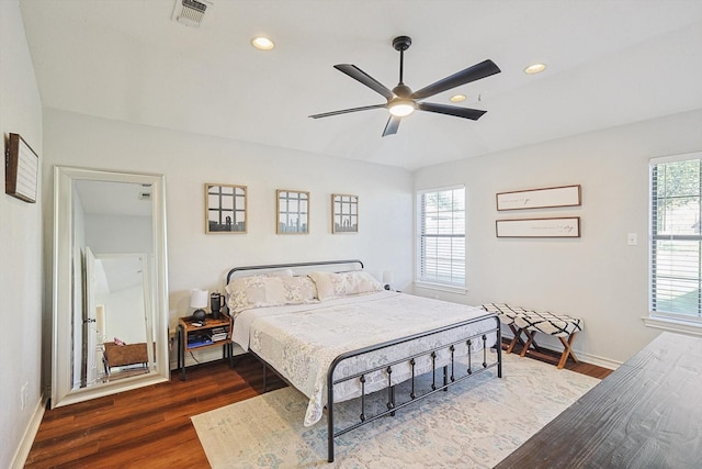 bedroom with multiple windows, ceiling fan, and dark hardwood / wood-style floors