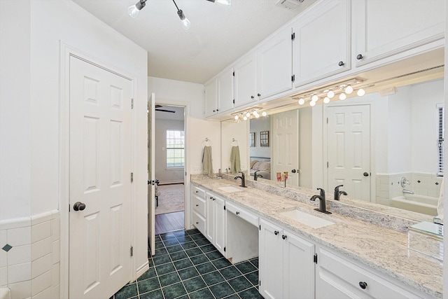 bathroom featuring a bathing tub, tile patterned flooring, and vanity