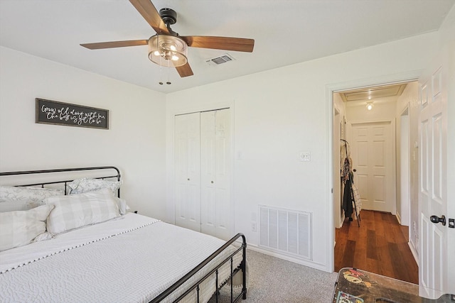 bedroom with dark colored carpet, ceiling fan, and a closet