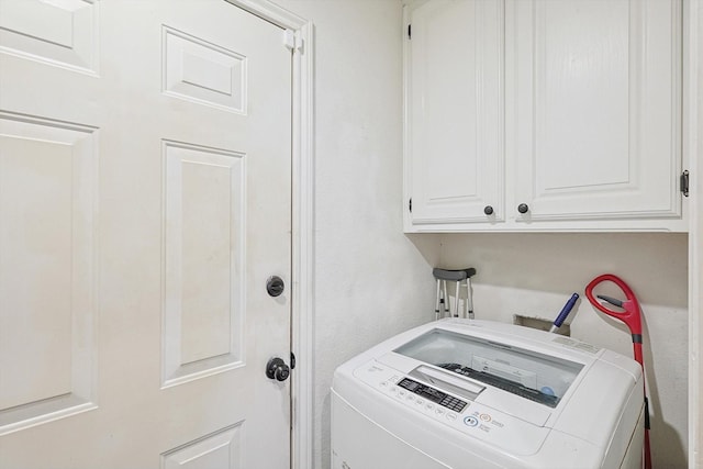 laundry room featuring cabinets and washer / clothes dryer