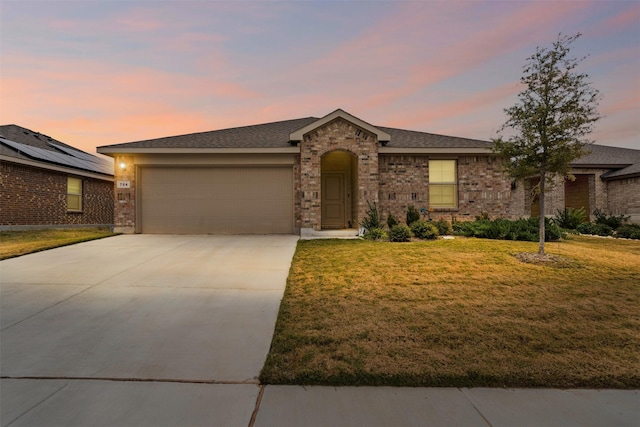 single story home with a garage and a lawn