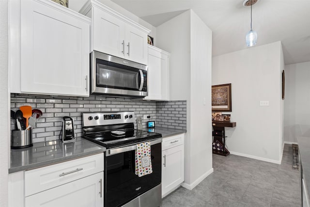 kitchen with pendant lighting, light tile patterned floors, tasteful backsplash, white cabinetry, and stainless steel appliances