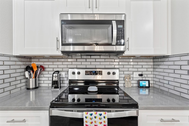 kitchen featuring white cabinets, backsplash, and appliances with stainless steel finishes