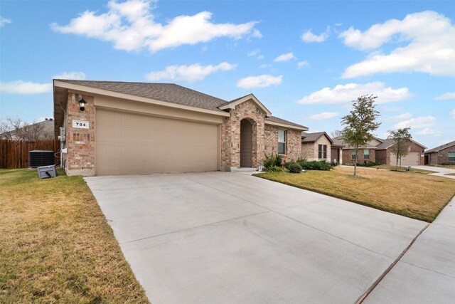 ranch-style home with central air condition unit, a front lawn, and a garage