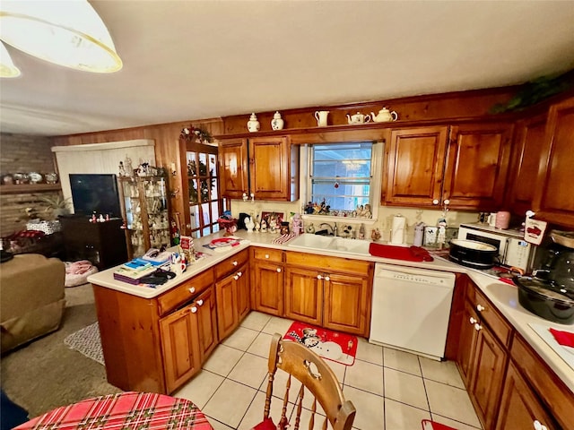 kitchen featuring dishwasher, kitchen peninsula, light tile patterned flooring, and sink