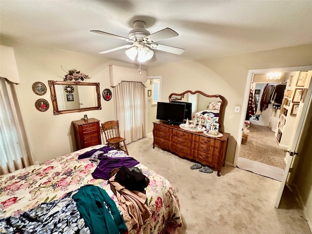 bedroom featuring light carpet, ceiling fan, a spacious closet, stainless steel refrigerator, and a closet