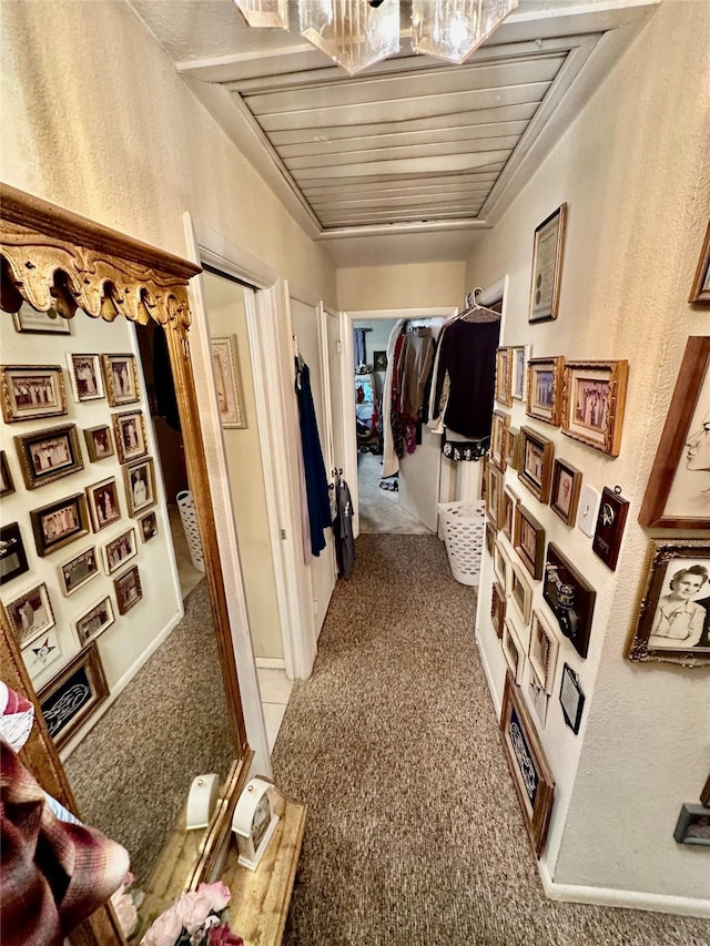 hall with carpet floors and wood ceiling