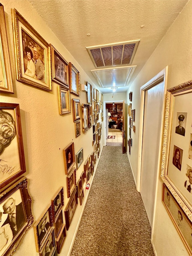 corridor with carpet flooring and a textured ceiling