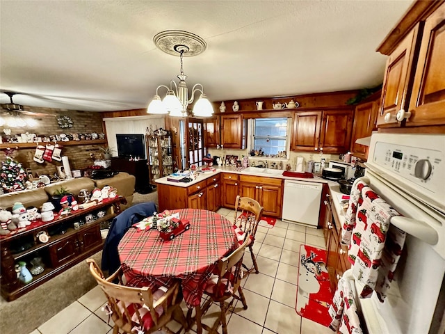 kitchen featuring ceiling fan with notable chandelier, sink, decorative light fixtures, dishwasher, and light tile patterned flooring