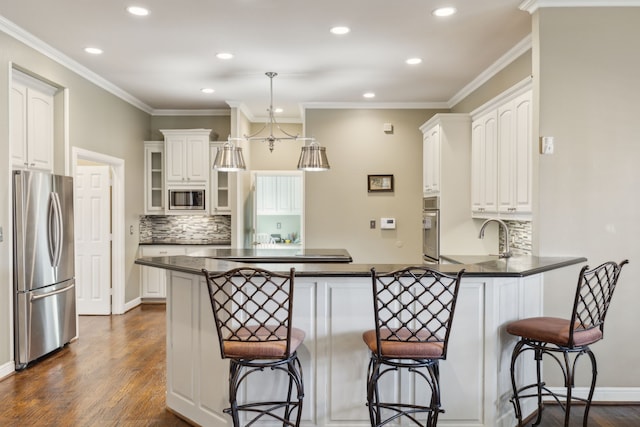 kitchen featuring white cabinetry, a breakfast bar area, kitchen peninsula, stainless steel appliances, and dark wood-type flooring