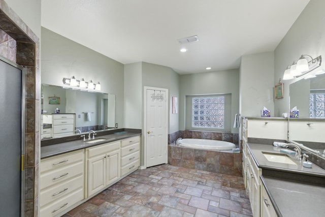 bathroom featuring vanity, separate shower and tub, and a wealth of natural light