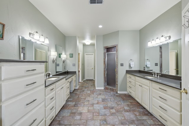 bathroom with a shower with door and vanity