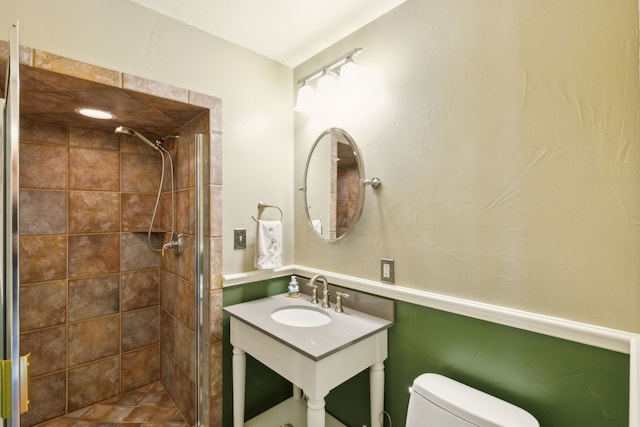 bathroom with vanity, tiled shower, and toilet