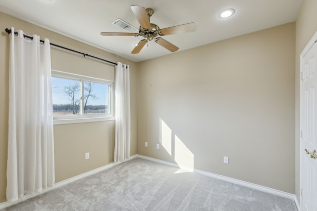 spare room with ceiling fan and light carpet