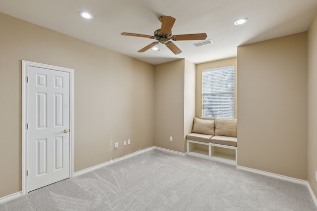 carpeted spare room featuring ceiling fan