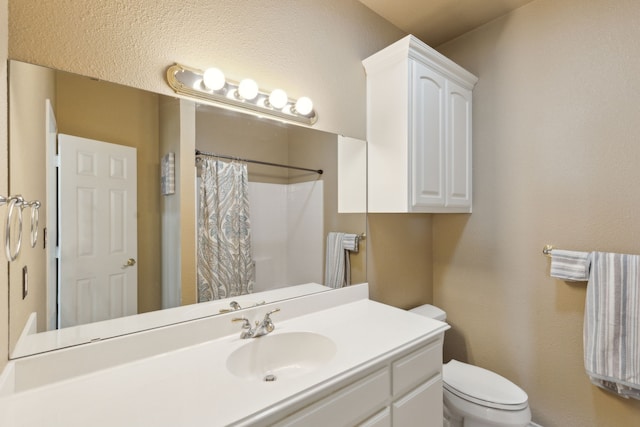 bathroom featuring walk in shower, vanity, and toilet