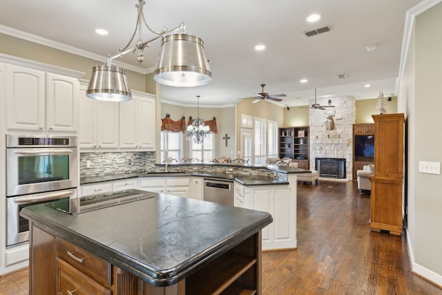 kitchen with white cabinetry, pendant lighting, a kitchen island, and appliances with stainless steel finishes