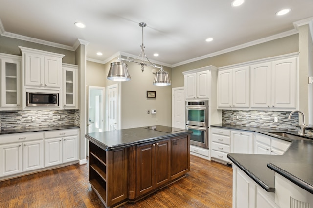 kitchen featuring sink, decorative light fixtures, white cabinets, and a kitchen island