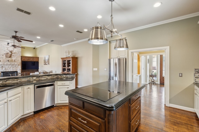 kitchen with stainless steel appliances, ornamental molding, hanging light fixtures, and white cabinets