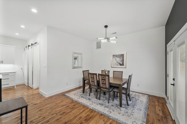 dining space featuring hardwood / wood-style floors and a barn door